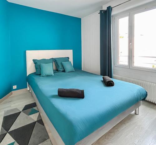 a blue bedroom with a large bed with blue walls at Proche Paris et Disneyland T2 calme avec Terrasse in Noisiel
