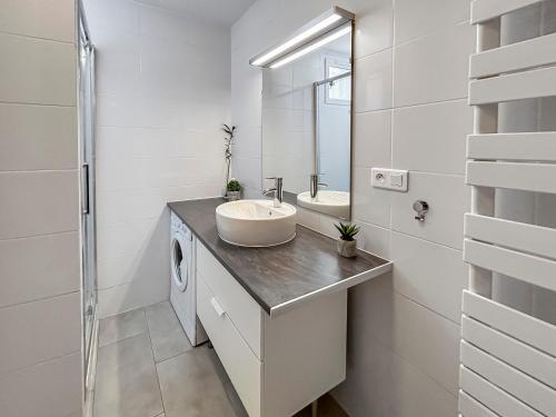 a white bathroom with a sink and a mirror at Proche Paris et Disneyland T2 calme avec Terrasse in Noisiel