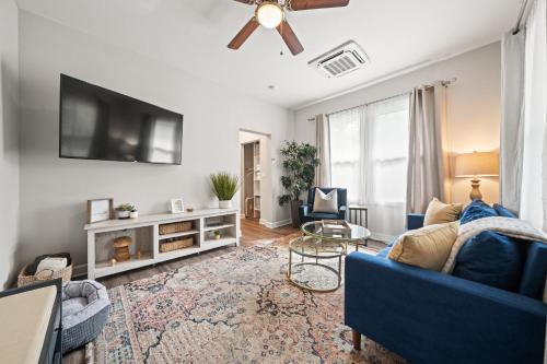 a living room with a blue couch and a tv at Spring Bungalow - A cozy getaway in downtown Hot Springs! in Hot Springs