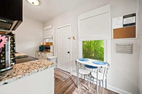 a kitchen with a table and two stools at Spring Bungalow - A cozy getaway in downtown Hot Springs! in Hot Springs