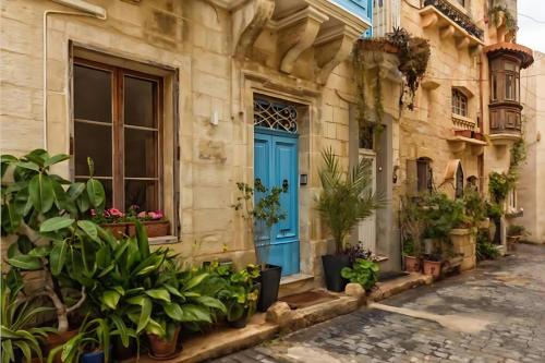 a blue door on a building with plants at Medieval Knights house GF with Seaview at the Three Cities Marina in Senglea