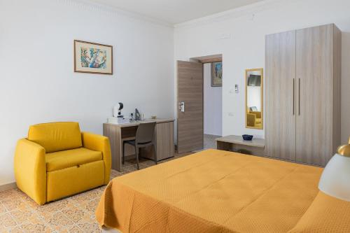 a bedroom with a bed and a chair and a desk at Al numero 1 in Nova Siri Marina