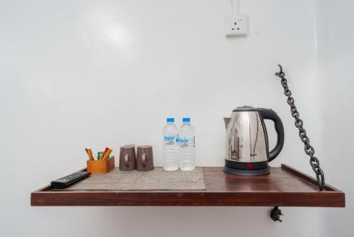 a shelf with a tea kettle and water bottles on it at The Golf Green City Bungalow in Nuwara Eliya