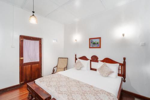 a bedroom with a bed and a wooden floor at The Golf Green City Bungalow in Nuwara Eliya