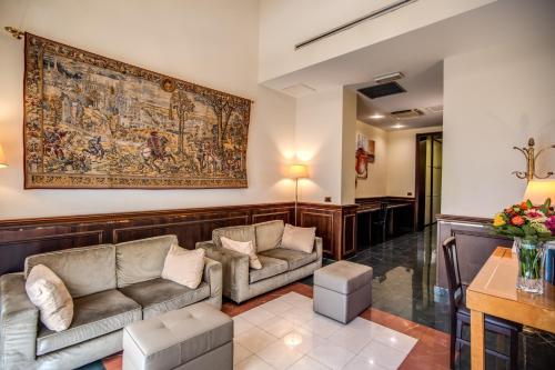 a living room with two couches and a tapestry at Hotel Diocleziano in Rome