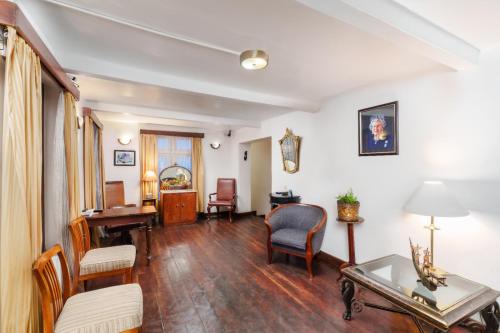 a living room filled with furniture and a table at The Golf Green City Bungalow in Nuwara Eliya