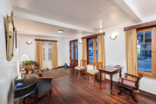 a living room with a table and chairs at The Golf Green City Bungalow in Nuwara Eliya