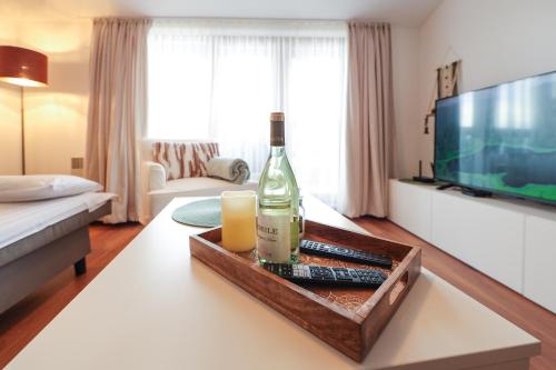 a living room with a bottle of wine on a table at Cozy 1BR With Spa Near Ski Lift in Bansko