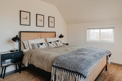 a bedroom with a large bed and a window at Luxe Gabel Farmhouse Fire Pit & Country Views in Callicoon