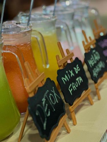 a table topped with glasses of orange juice and cookies at Pousada Palmeiras Bombinhas in Bombinhas