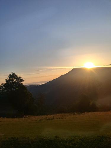 a sunset over a mountain with the sun setting on the horizon at Kamp Kruščić - Laništa in Mojkovac