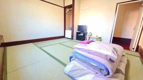 a room with several pillows laying on the floor at ビジネス旅館 錦荘 - Nishiki Guest House in Kadoma