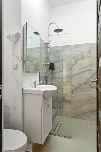 a white bathroom with a sink and a toilet at Selari Boutique in Bucharest