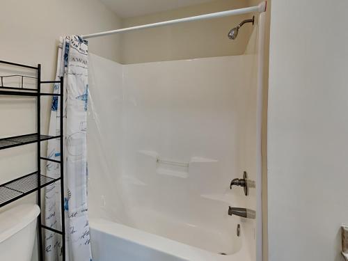 a bathroom with a shower and a white tub at Lovin Lowe Tide in Thomas Landing