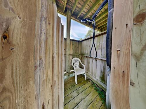 a wooden house with a chair on a porch at Lovin Lowe Tide in Thomas Landing