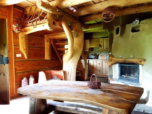 a room with a wooden table and a fireplace at Domki Osada Werdołyna in Polańczyk