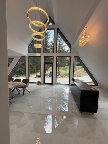 a large living room with a chandelier and a table at Pine Hill 2 in Poiana Mărului