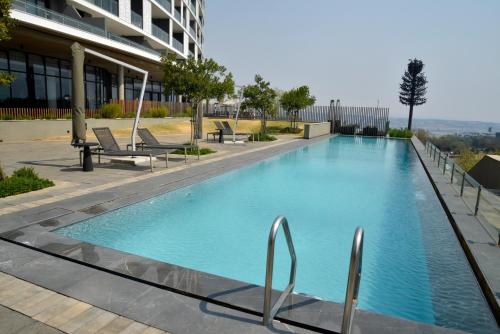Una gran piscina azul frente a un edificio en Luxury Escape at Ellipse 1-Bed, Kitchen, Wi-Fi & Free Parking, en Midrand