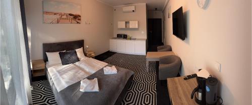 una piccola stanza con un letto e un divano di SoLo a Kołobrzeg