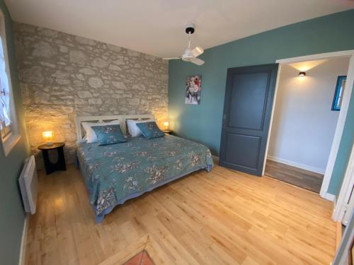a bedroom with a bed and a wooden floor at Petit Rousset Gite Cerise in Eymet