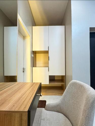 a room with a table and a chair and cabinets at Executive Pre 2 bedroom apartment in Surulere
