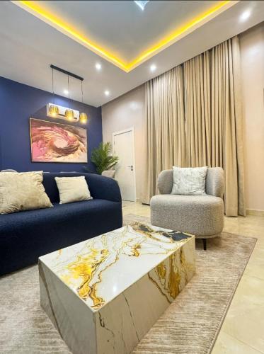 a living room with a blue couch and a table at Executive Pre 2 bedroom apartment in Surulere