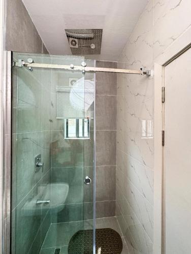 a shower with a glass door in a bathroom at Executive Pre 2 bedroom apartment in Surulere