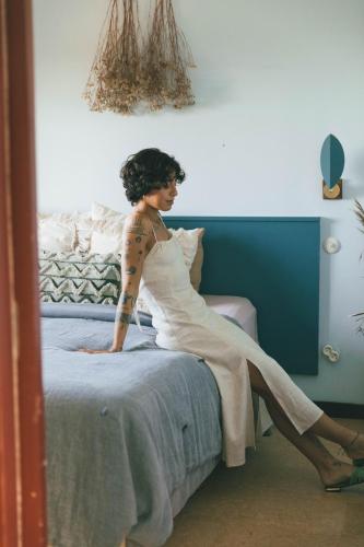 a woman sitting on top of a bed at Eco-lodge Villa Epicurea in Sesimbra