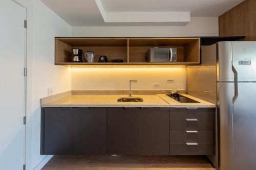 una cocina con fregadero y refrigerador en BHomy Caraibas, en São Paulo