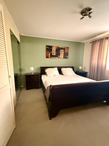 a bedroom with a large bed and a ceiling fan at Bon Bini na Curacao in Willemstad