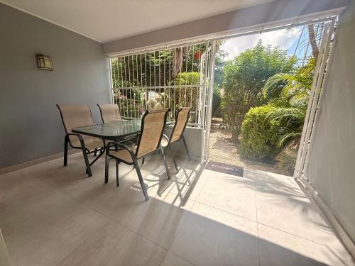 ein Esszimmer mit Tisch und Stühlen und einem Fenster in der Unterkunft Bon Bini na Curacao in Willemstad