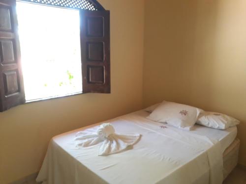 Village Pousada Canedo في غايبيم: غرفة نوم مع سرير مع قوس عليه