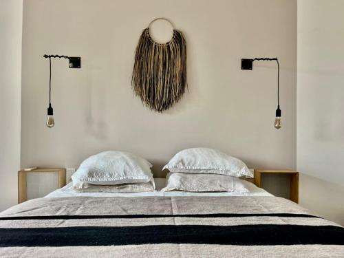 a bedroom with a bed with two pillows at Arty Provence, vue, calme et piscine chauffée dans les Alpilles proche St-Rémy-de-Provence in Saint-Étienne-du-Grès