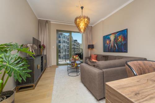 a living room with a couch and a chandelier at Port de la Mer Luxury Sleeps 4Person in Dubai