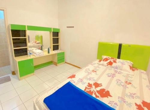 a bedroom with a bed and a sink and a mirror at PRO Batu Embun Pagi Hotel in Punten