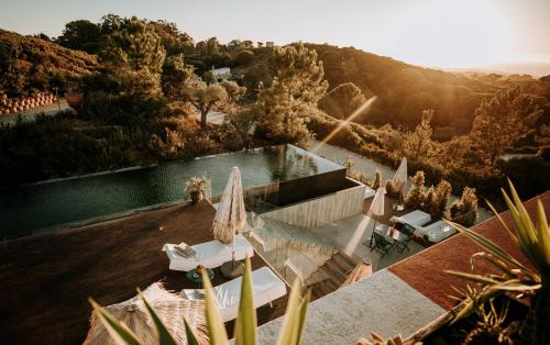 an aerial view of a pool with umbrellas at Eco-lodge Villa Epicurea in Sesimbra
