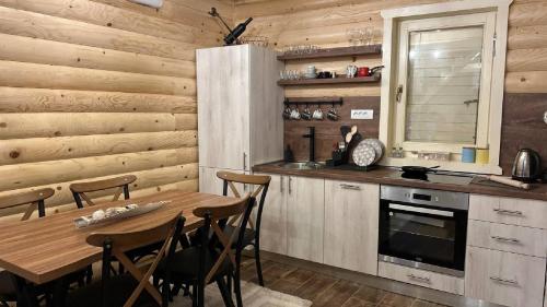 a kitchen with a table and a wooden wall at Golden Eagle Jelovica in Berane