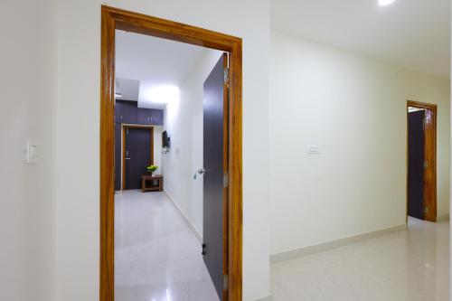 a hallway with a mirror and a white wall at SBHS Venkatadri Homestay in Tirupati