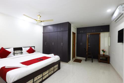 a bedroom with a large bed with red pillows at SBHS Venkatadri Homestay in Tirupati