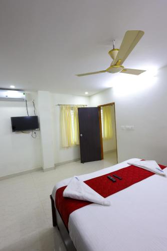 a bedroom with a bed and a ceiling fan at SBHS Venkatadri Homestay in Tirupati