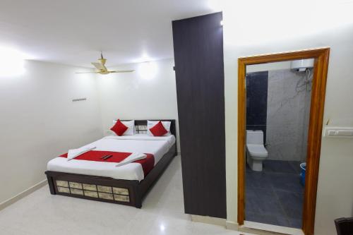 a bedroom with a bed and a bathroom with a toilet at SBHS Venkatadri Homestay in Tirupati