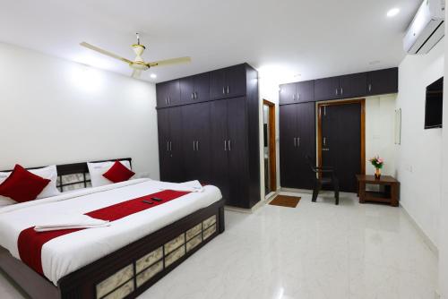 a bedroom with a large bed with red pillows at SBHS Venkatadri Homestay in Tirupati