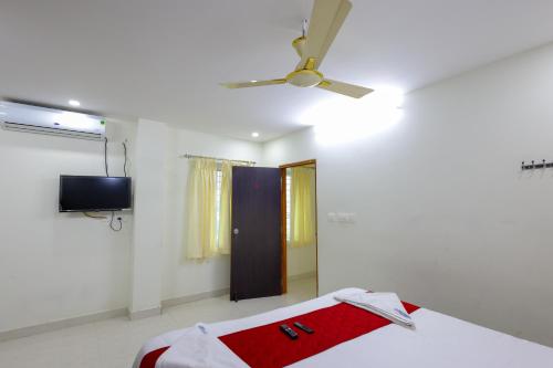 a bedroom with a ceiling fan and a bed at SBHS Venkatadri Homestay in Tirupati