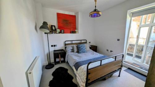 a bedroom with a bed in a room with a window at 1 Bed with Balcony in Maidenhead by Elizabeth Line in Maidenhead