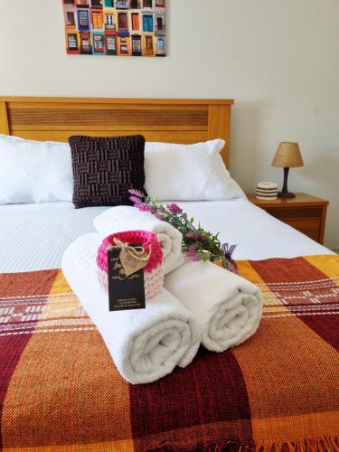 a bed with towels and flowers on it at Ao lado da Igreja Matriz, Hospedagem de Charme in Santa Rita do Sapucaí