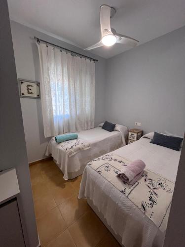 a room with two beds and a window at Casa coqueta con jardin in La Redondela