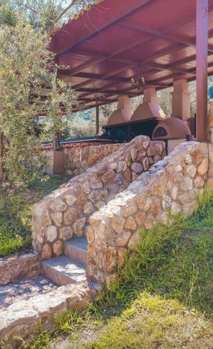a stone wall with stairs in front of a house at Aroma studios&apartments 2 in Vourvourou