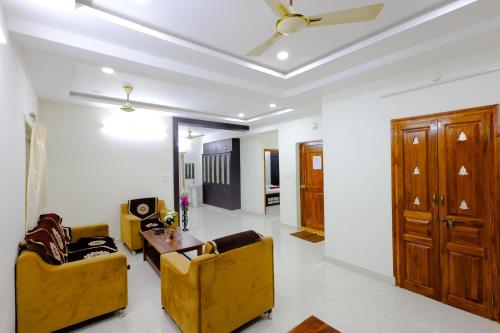a living room with couches and a ceiling fan at SBHS Venkatadri Homestay in Tirupati