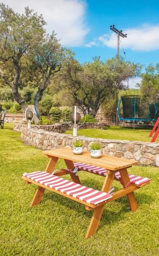 a picnic table and bench in a park at Aroma studios&apartments 2 in Vourvourou