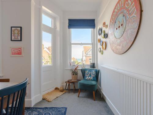 a hallway with a blue chair and a window at The Lynton Lookout in Margate